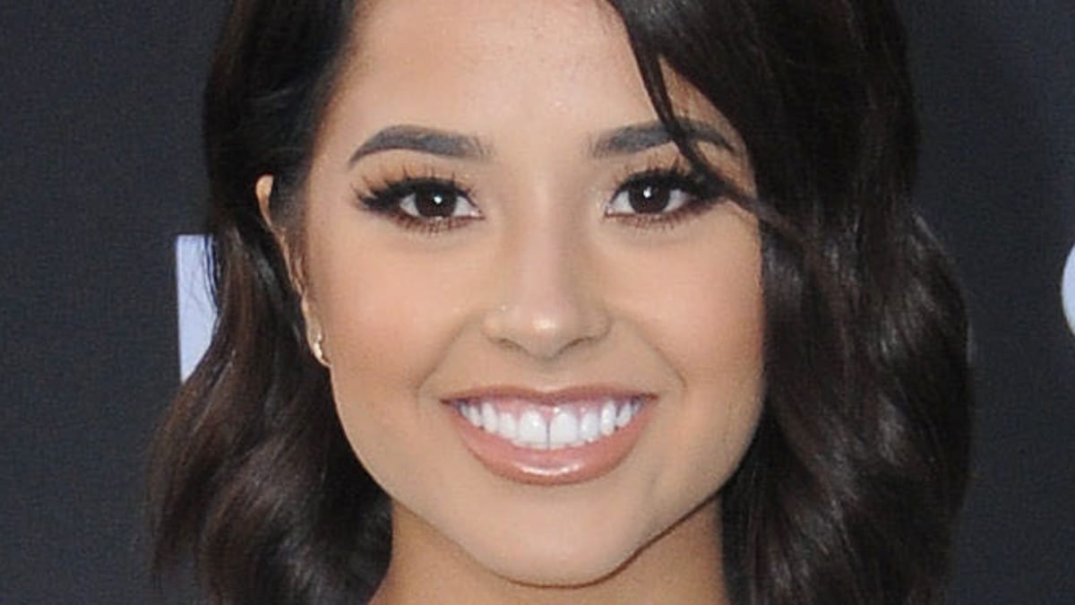 Becky G smiles for the camera on red carpet.