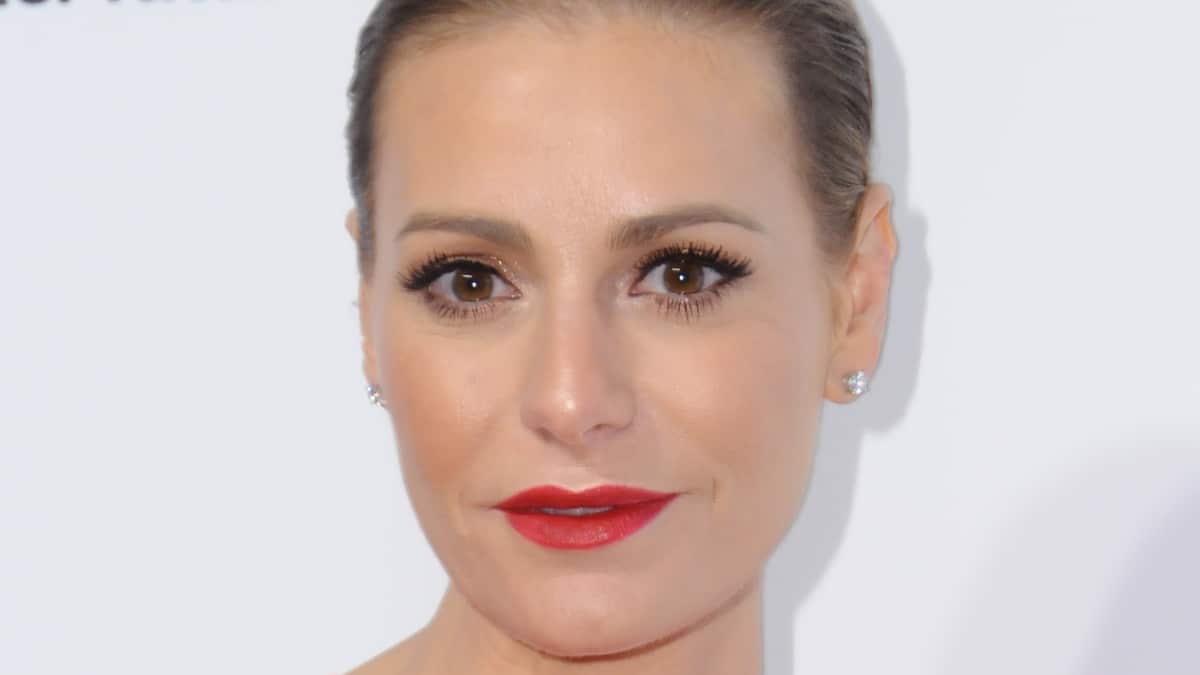 Dorit Kemsley smiles on the red carpet in red lipstick.