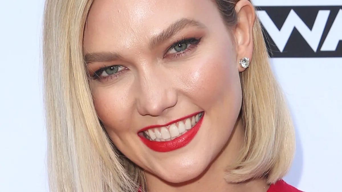 Karlie Kloss flashes her bright smile with red lipstick.