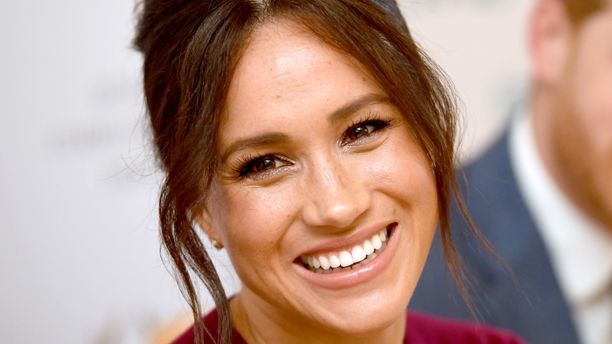 Meghan Markle smiles into the camera.