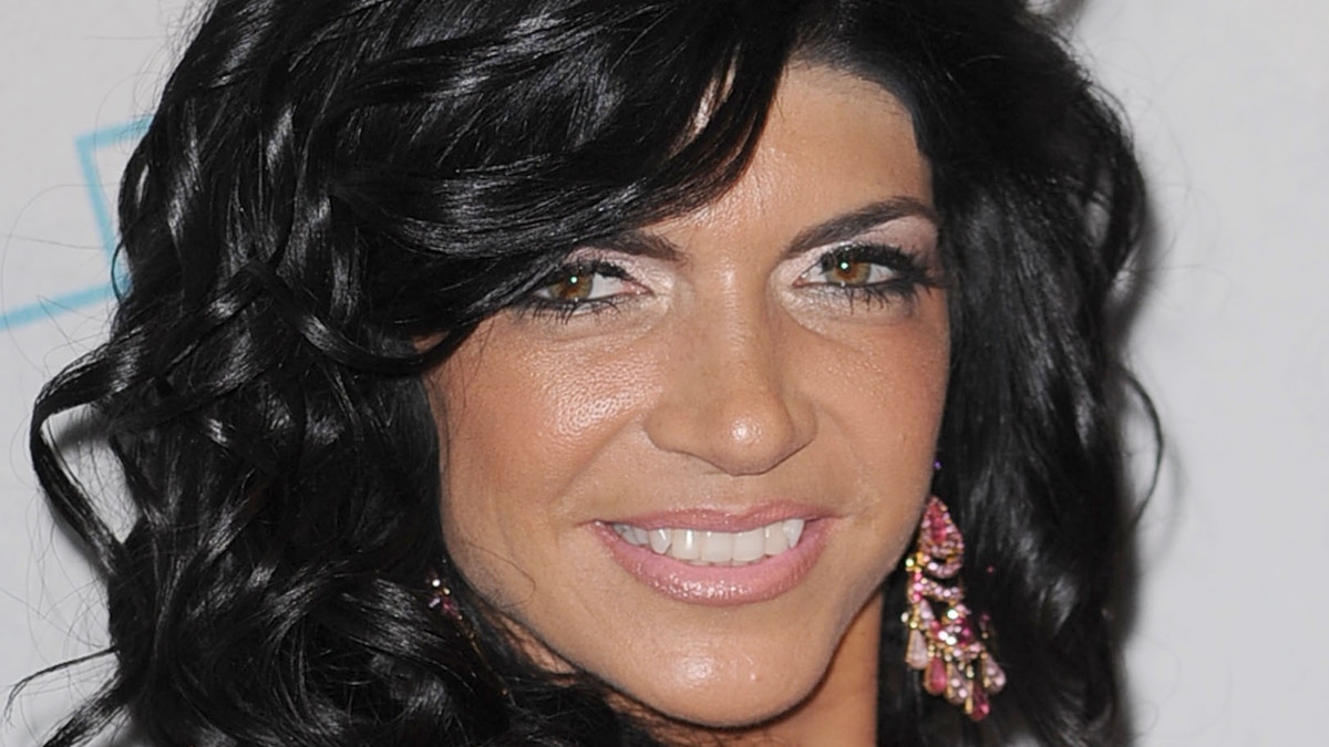 Teresa Giudice smiles with pink earrings on the red carpet.