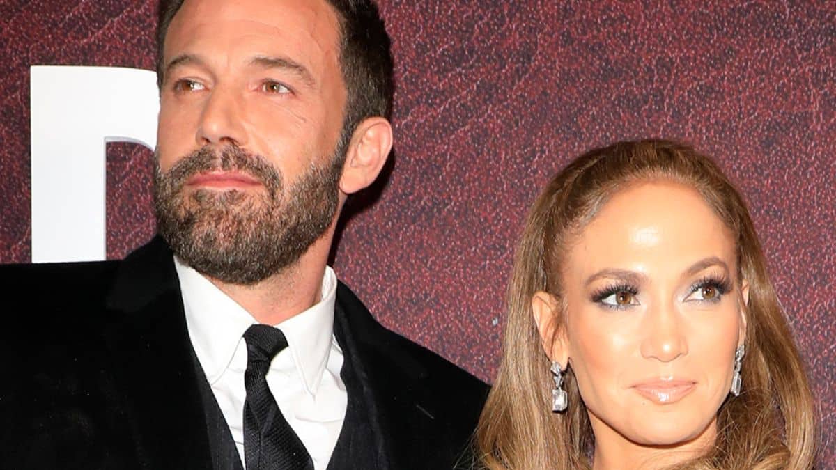 Ben Affleck in a suit and Jennifer Lopez in a light blue dress at a movie premiere