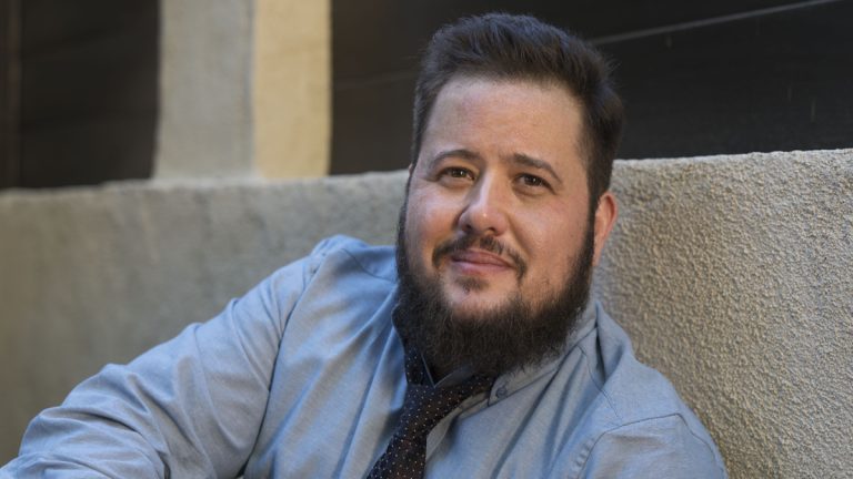 Chaz Bono wearing a blue shirt and a darker blue tie.