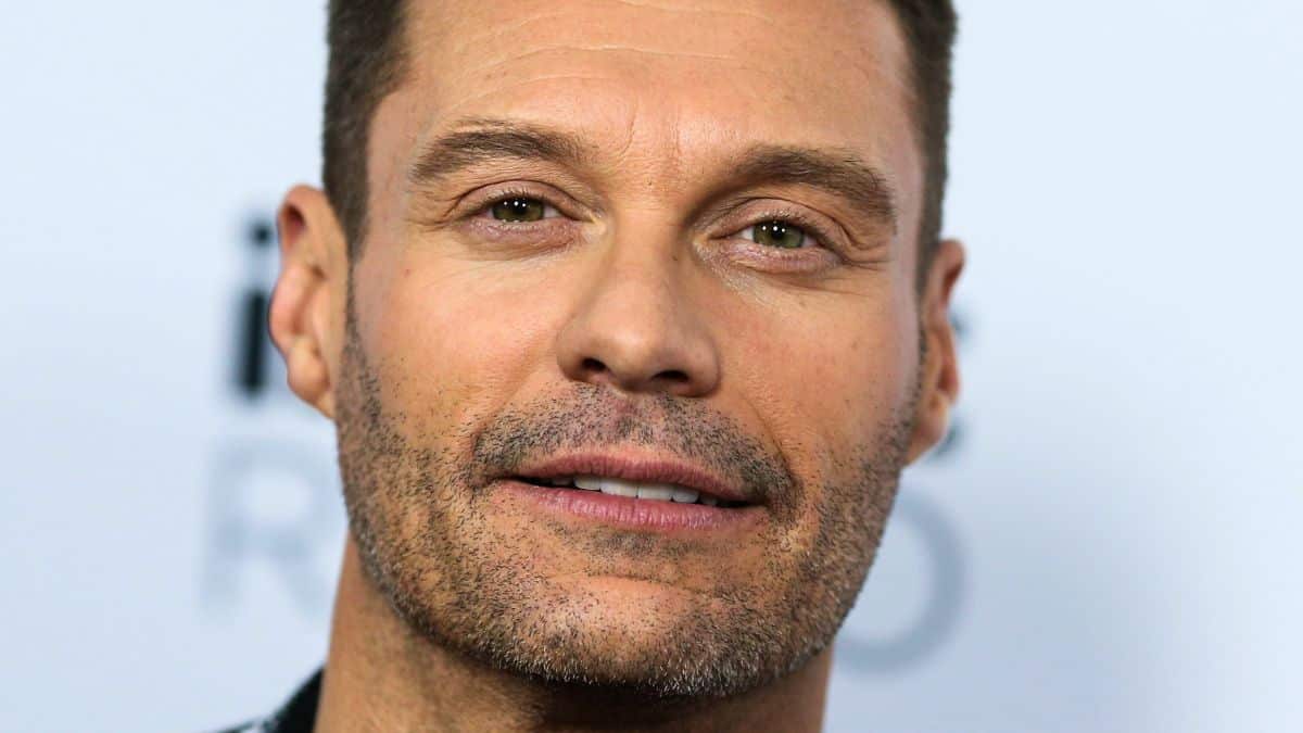 ryan seacrest poses on the red carpet at The Forum in los angeles